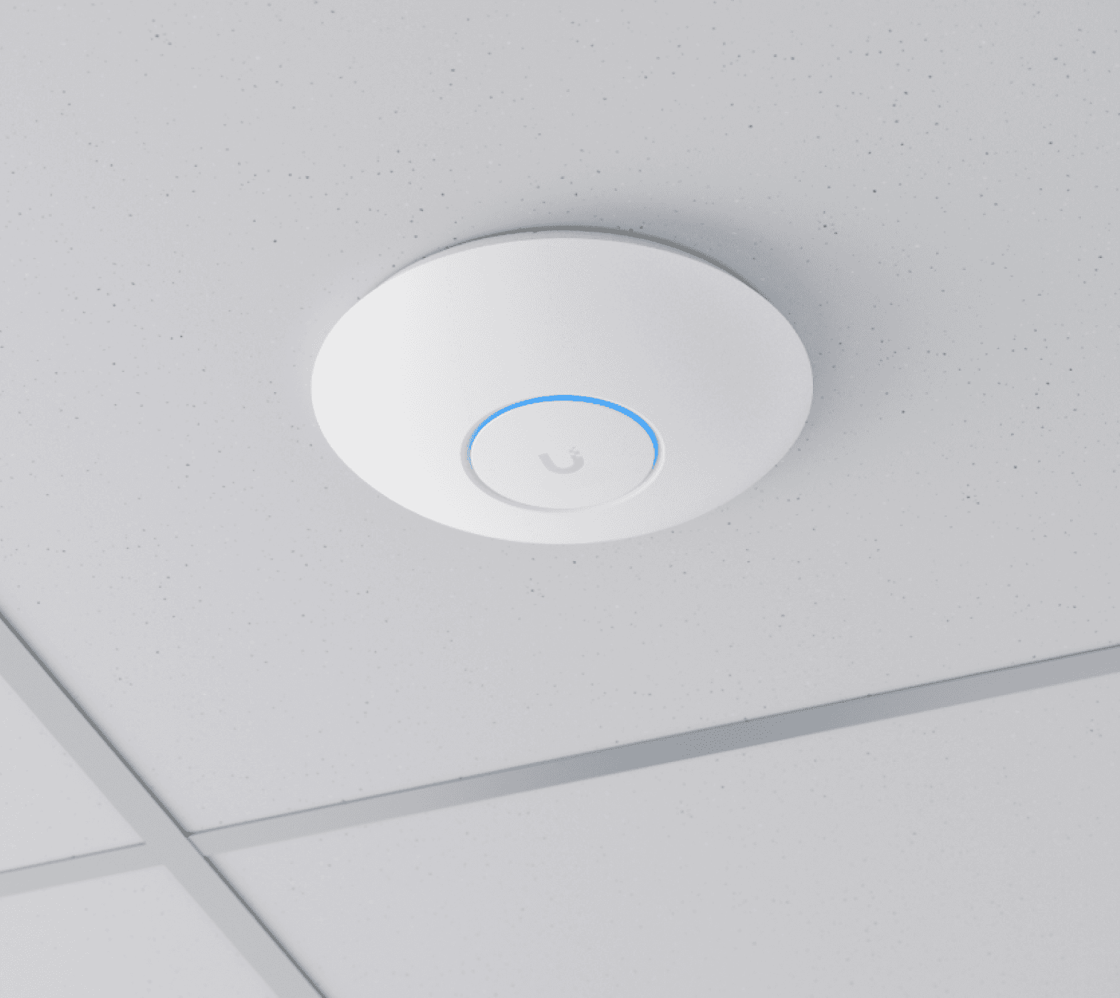 Access point UniFi de teto instalado em forro modular, com anel indicador luminoso e alimentação exclusivamente por PoE sobre o cabeamento estruturado — modelo disponível também em regime de comodato