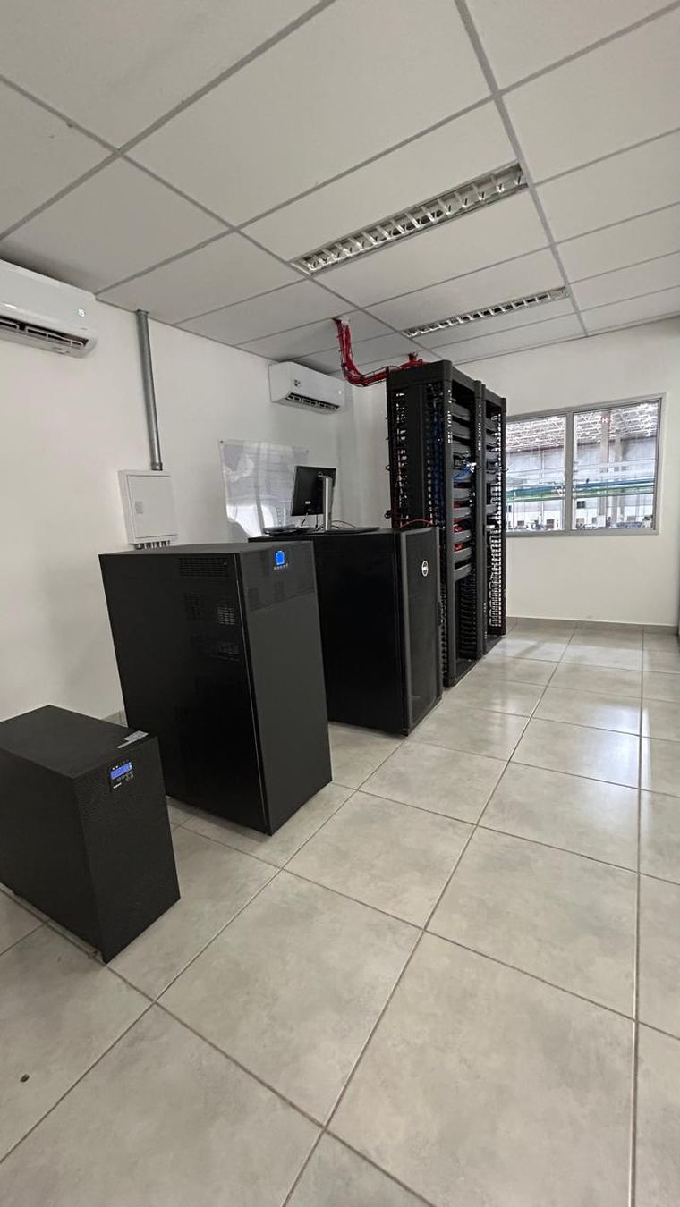 Sala técnica com rack de servidores, nobreaks redundantes e ar-condicionado dedicado