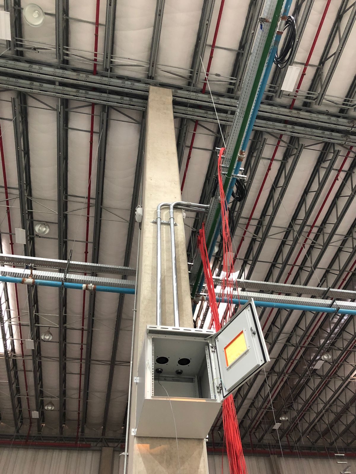 Rack aéreo de 18U com proteção IP67 e filtro, instalado no teto de galpão industrial