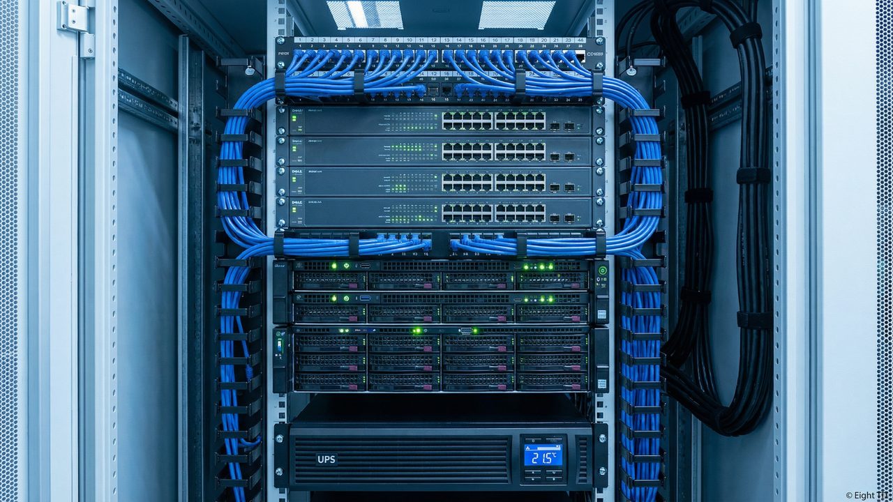 Rack de TI organizado com patch panel, switches gerenciáveis, servidores, UPS e gestão de cabos — padrão Eight TI